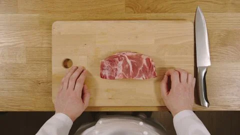 TOP VIEW: Cook ready to cut pork on a cutting board Stock Photos