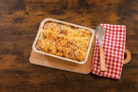 Top view of cooked lasagna in a dish on a wooden board Foto stock