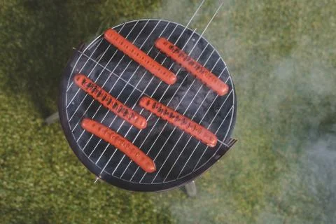 Top view of cooking process of hot dog sausages on grill Stock Photos