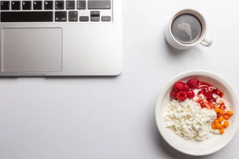 Top view, copyspace, white table, computer, coffee, curd and jam Stock Photos