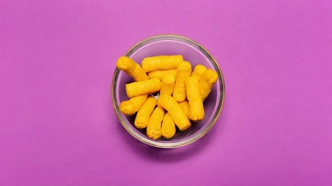 Top view of corn puff snacks, disappear from the bowl. Background of pink color. Stock Footage 147022696