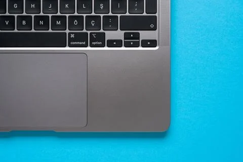 Top view of corner and keyboard of laptop on blue table Stock Photos