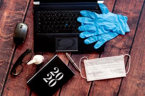 Top view of coronavirus remote work kit on wooden office desk with hand sanit Stock Photos