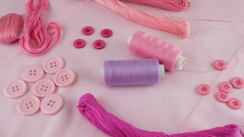 Top view of cotton fabric, buttons and spools of threads, floss, yarn  Vídeo Stock 290793438