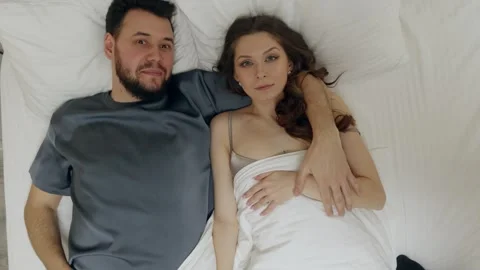 Top view couple falling onto bed, playful intimacy 動画素材 327927641