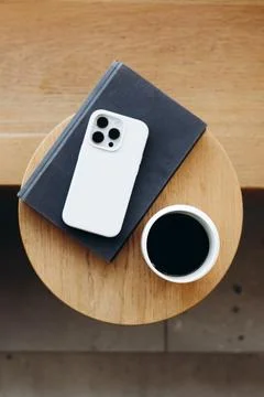 Top view of a cozy cafe table with a cup of coffee, book and a smartphone. Stock Photos
