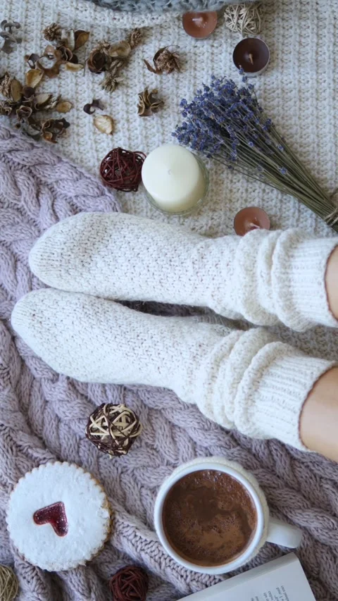 Top view cozy knitted socks on bed. Feet in warm socks covered with soft blanket Stock Footage 281645056