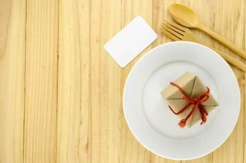 Top view of craft gift box on dish on wood background concept food for gift Stock Photos