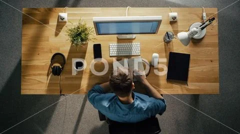 Top View of a Creative Designer working on His Desktop Computer, Writing Down Stock Photos