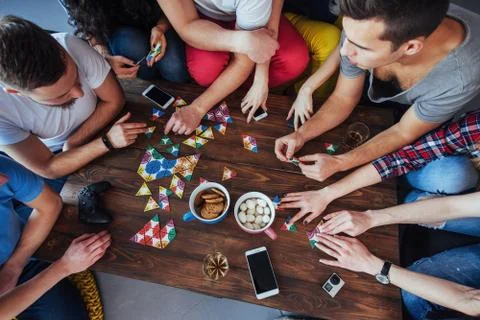 Top view creative photo of friends sitting at wooden table.  having fun while Stock Photos