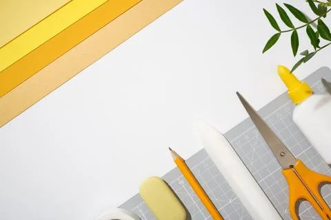 Top view creative workspace with cutting mat, scissors, glue, pencil and yell Stock Photos