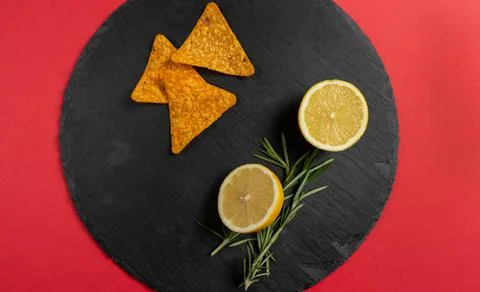 Top view of crispy corn triangles on a slate plate with half a lemon and some Stock Photos
