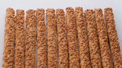 Top view. Crispy pretzel sticks coated with sesame seeds. Slider shot. Stock Footage 296517427