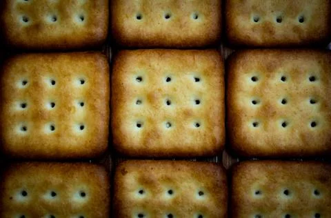 Top view of crispy square shaped biscuits. Salt and sweet biscuits. Stock Photos