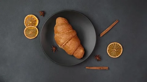 Top view of a Croissant Lying on a black Plate against a black background Stock Footage 237313468