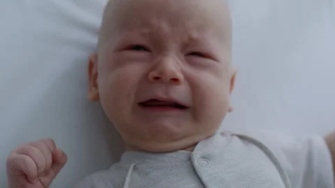 Top view, crying newborn baby lying in bed. Motherhood Stock Footage 306000893