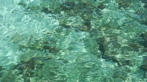 Top View of crystal clear ocean waves with rocks on sand bottom Stock Footage 78556932