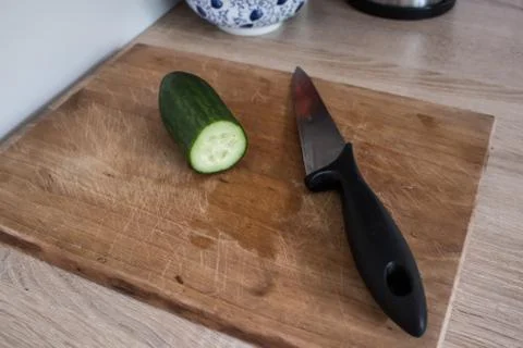 Top view of cucumber and  knife ready to cutting on chopping board in the kit Stock Photos