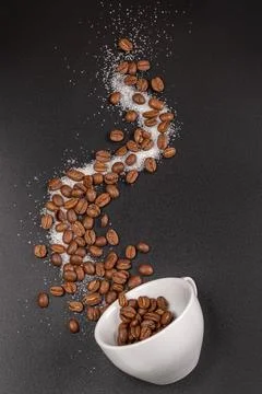 Top view, cup on black background and coffee beans Stock Photos