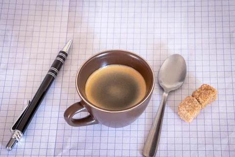 Top view of a cup of coffee with sugars and a pen Stock Photos