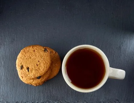 Top view on a cup of tea and cookies isolated on a dark background, close-up Stock Photos