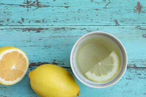Top view of Cup of tea and fresh lemon on light blue painted Stock Photos
