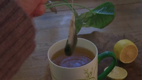 Top view of a cup of tea being brewed with a tea bag in a cozy winter interior.  Stock Footage 328108231