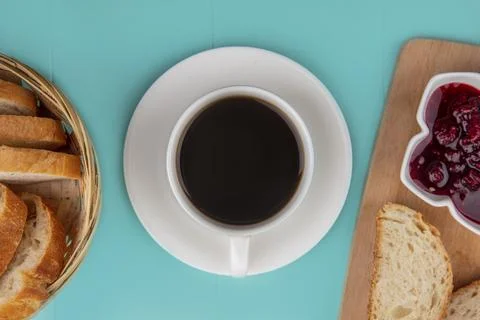 Top view of cup of tea with bread slices and raspberry jam on cutting board.. Фото