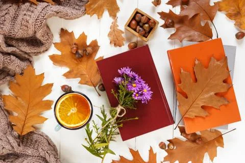 Top view of cup of tea with orange. Autumn leaves, a warm scarf on wooden bac Stock Photos