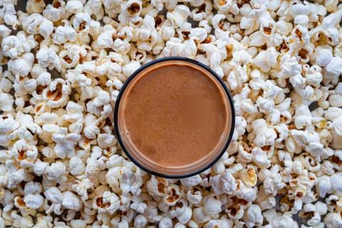 Top view of cup of tea placed among background of homemade popcorns. Homemade Stock Photos