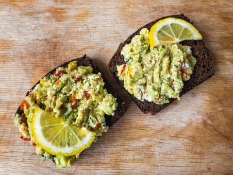Top view on cut board with  two  sandwiches with guacamole Foto stock