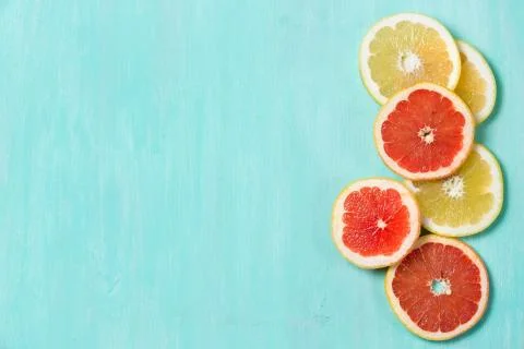 Top view on cut red and yellow grapefruit on turquoise wooden background. Stock Photos