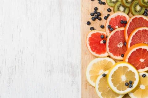 Top view on cut red and yellow grapefruit. Fresh organic citrus, kiwi and blu Stock Photos