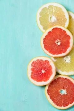 Top view on cut red and yellow grapefruit on turquoise wooden background. Jui Stock Photos