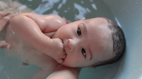 Top view of Cute baby having bath. Mother holds and bathes baby Stock Footage 204072142