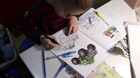 Top view of a cute boy working on hid colouring book. Stock Footage 300501896