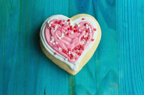 Top view of cute heart shaped cookie with pink and white frosting and heart c Stock Photos