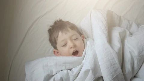 Top view of cute little boy stretching in bed at home Stock Footage 101226274
