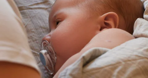 Top view of cute two month old baby with soother lying on back Stock Footage 100663828