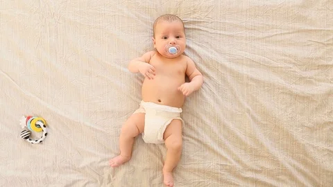 Top view of cute two month old baby with soother lying on back Stock Footage 100667529