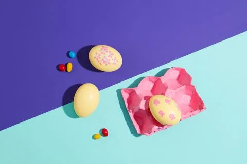 Top view of cute yellow Easter eggs decorated with pink blister and chocolate Foto stock