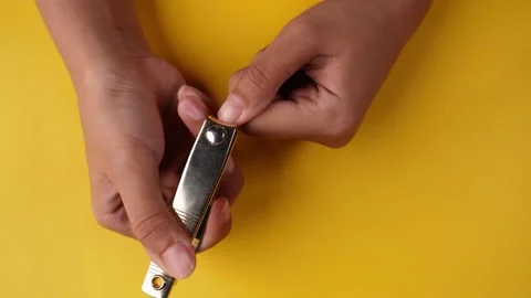 Top view cutting fingernails isolated yellow background Stock Footage 275885727