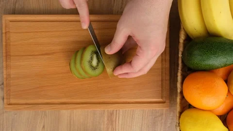 Top view of cutting kiwi fruit on the kitchen table Stock Footage 273048289
