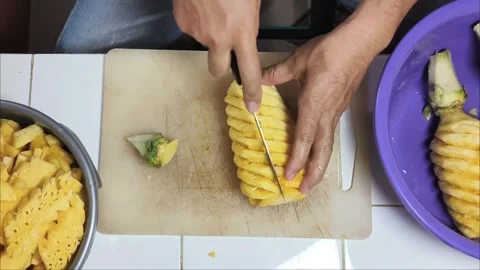 Top View cutting the pineapple into small pieces to put into the juicer. Stock Footage 341958257