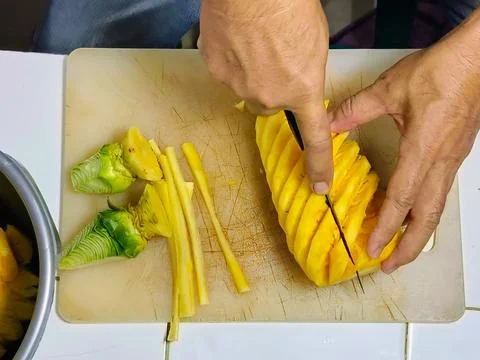 Top View cutting the pineapple into small pieces to put into the juicer. Stock Photos