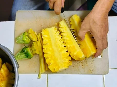 Top View cutting the pineapple into small pieces to put into the juicer. Stock Photos