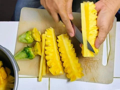 Top View cutting the pineapple into small pieces to put into the juicer. Stock Photos