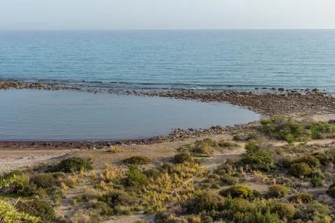 Top view of a Cyprus beach with sparse coastal shrubs and calm Mediterranean  Stock-Fotos