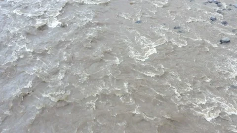 Top view of a dangerously fast flowing river with a brown coloration Stock Footage 143676414