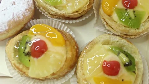Top view of Danish Fruit Tarts and Powdered Donuts in Box. Stock Footage 280216261